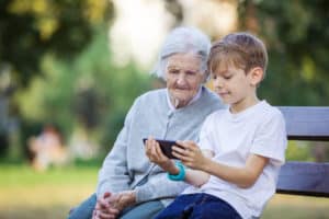 Grandson showing grandmother funeral live stream on mobile phone